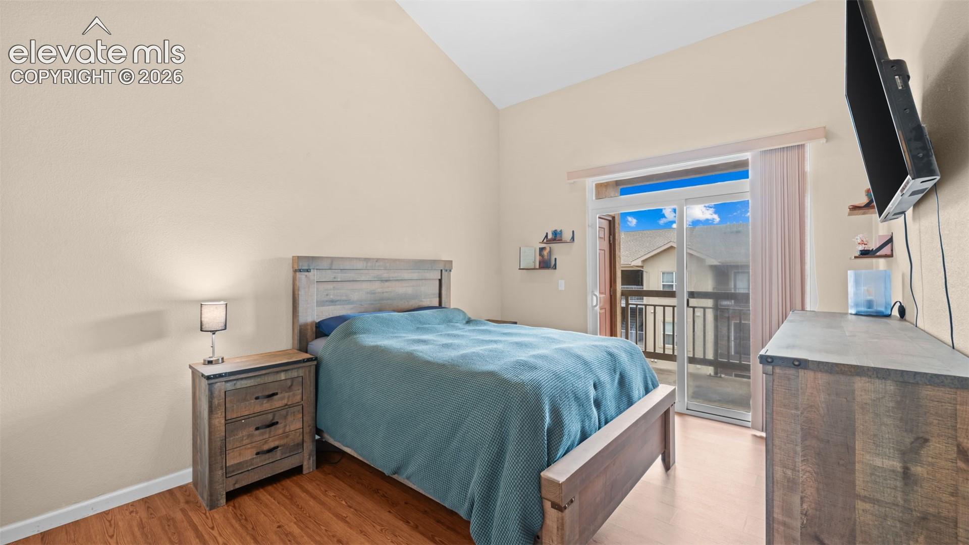 Room featuring vaulted ceilings and wood-finish flooring