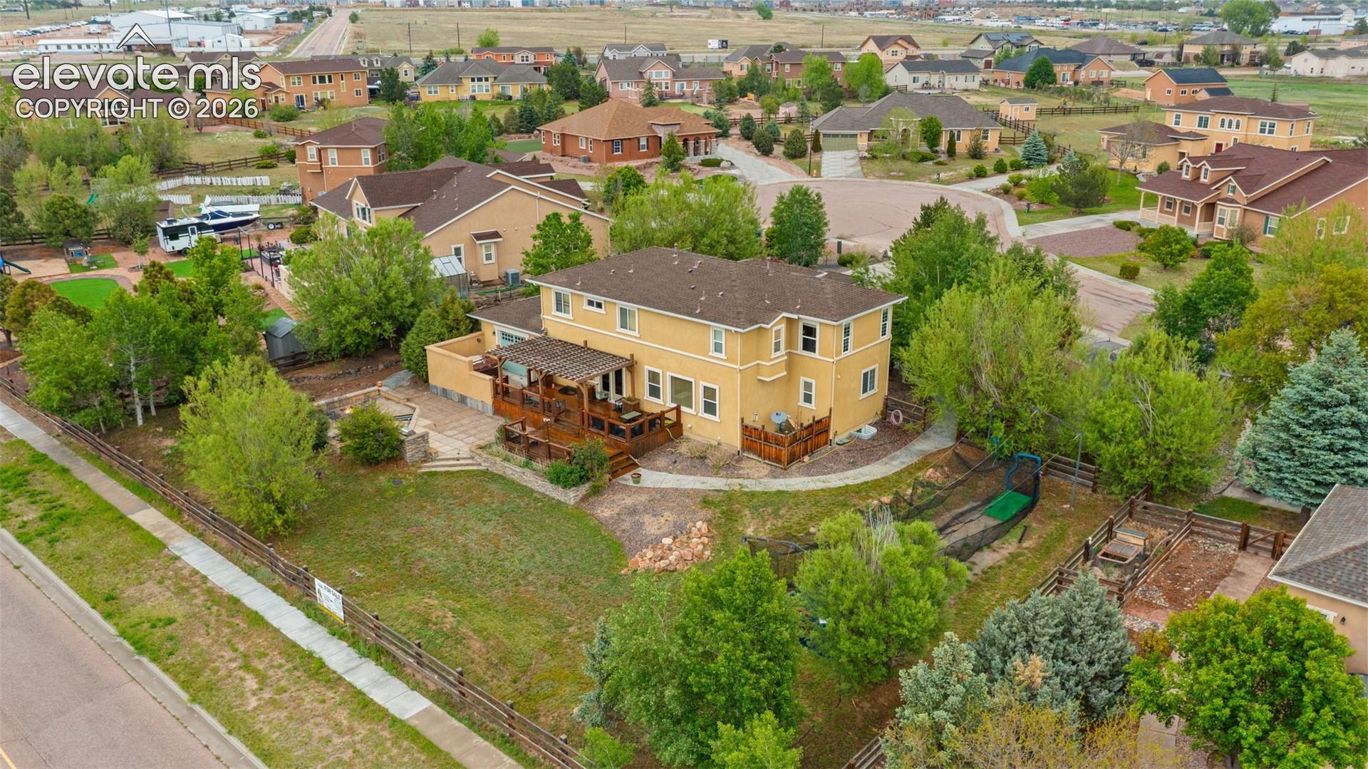 Yellow exterior with multiple decks, extensive landscaping, and a fenced yard
