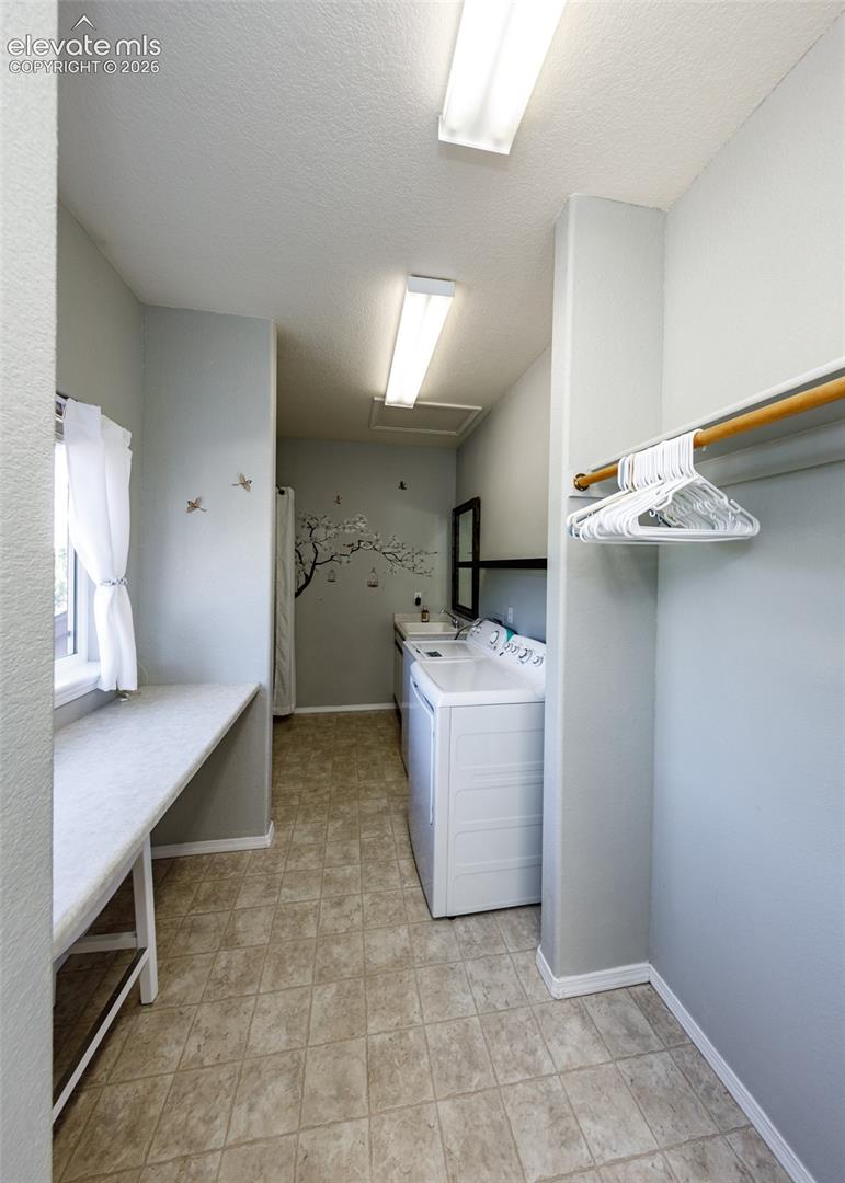 Utility space featuring built-in shelving, a dedicated countertop workspace, integrated clothing rod, and square tile flooring