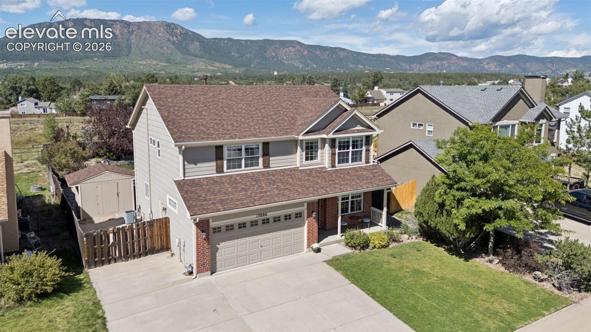 Two-story residence with a two-car garage, brick and siding exterior, and a covered front porch