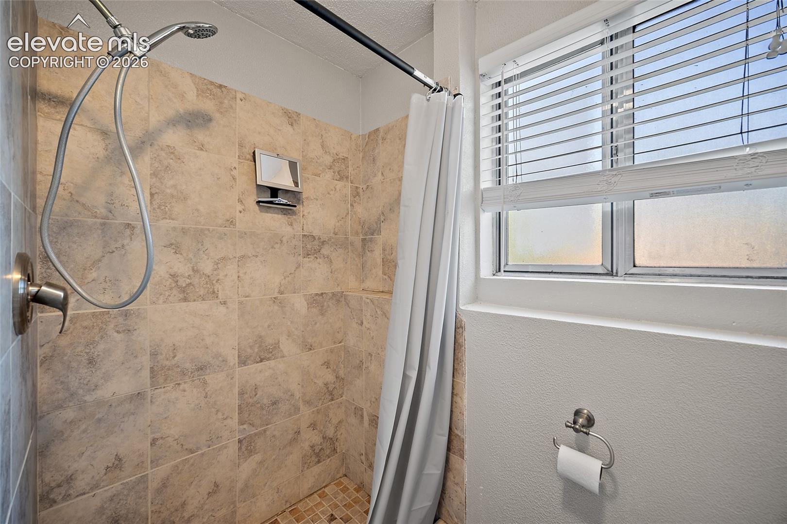 Bathroom with updated fixtures and tiled shower.