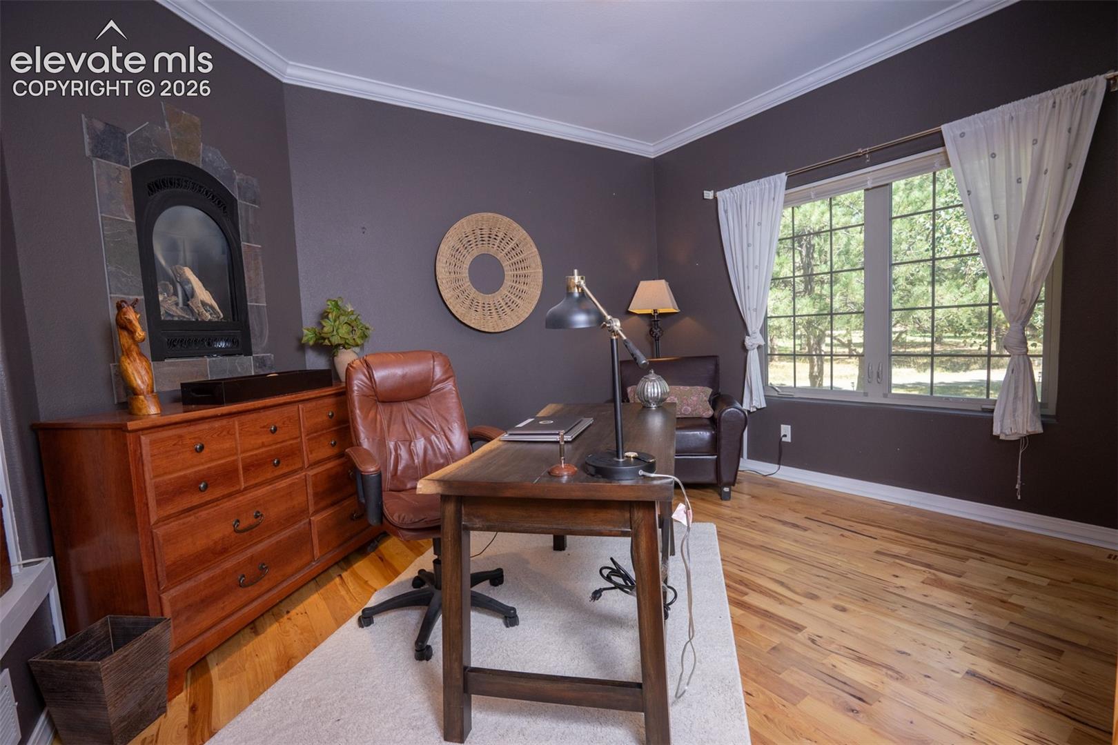 This is the bedroom off the entry. It has a double door entrance, large walk-in closet, and even a fireplace. Currently serving as an in-home office. Notice the beautiful hardwood floors, too!
