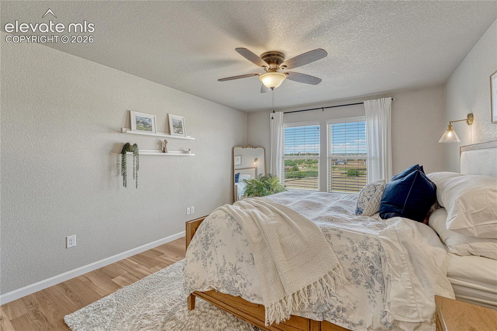 The primary bedroom provides a calming retreat with large windows showcasing scenic community views.