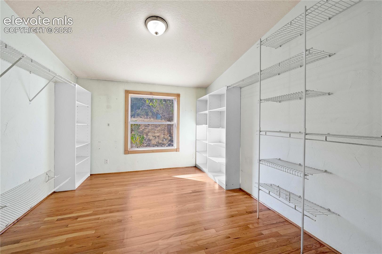 Spacious closet with lofted ceiling and wood-type flooring
