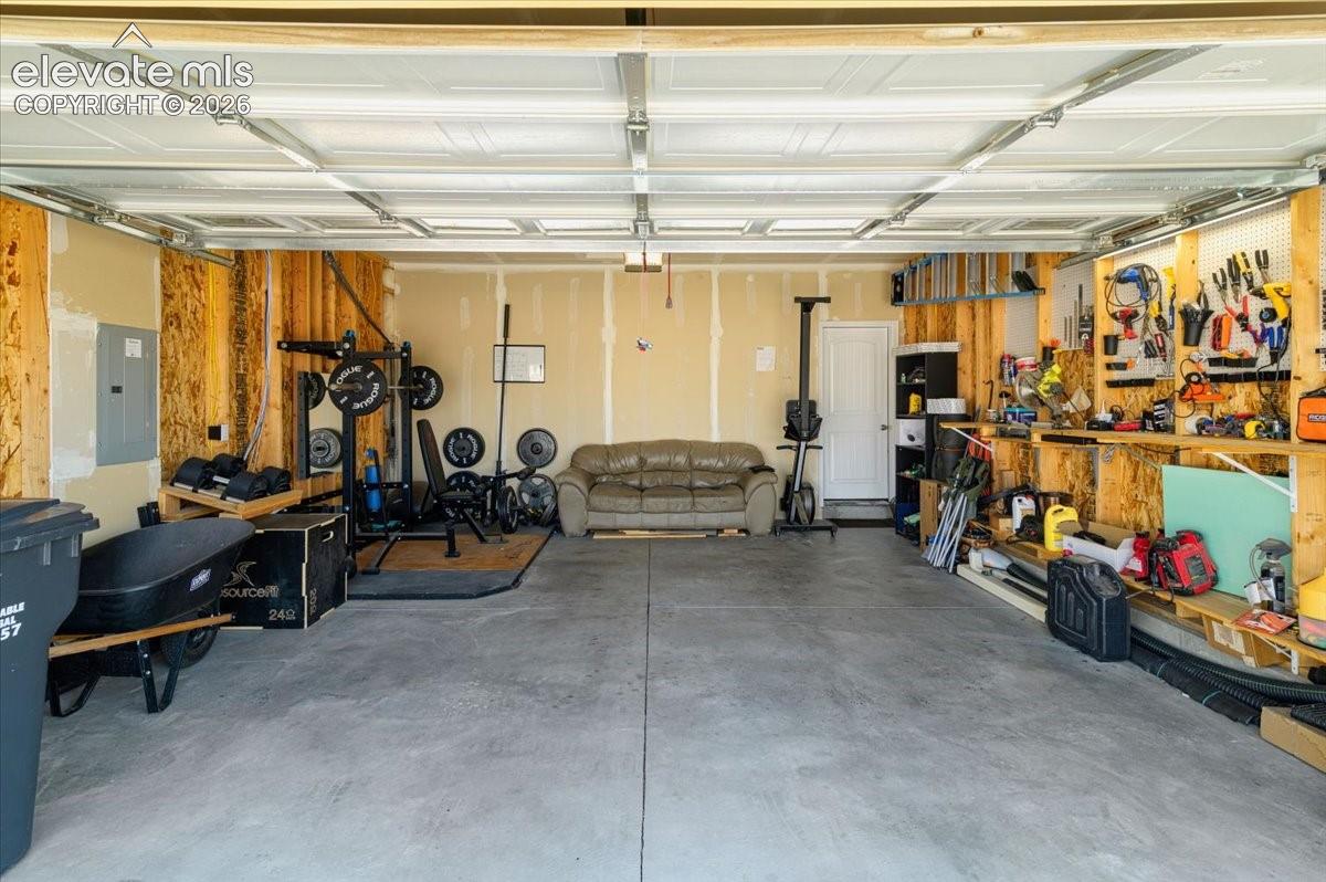 Concrete flooring in a multi-car garage with overhead garage door track system, and built-in shelving