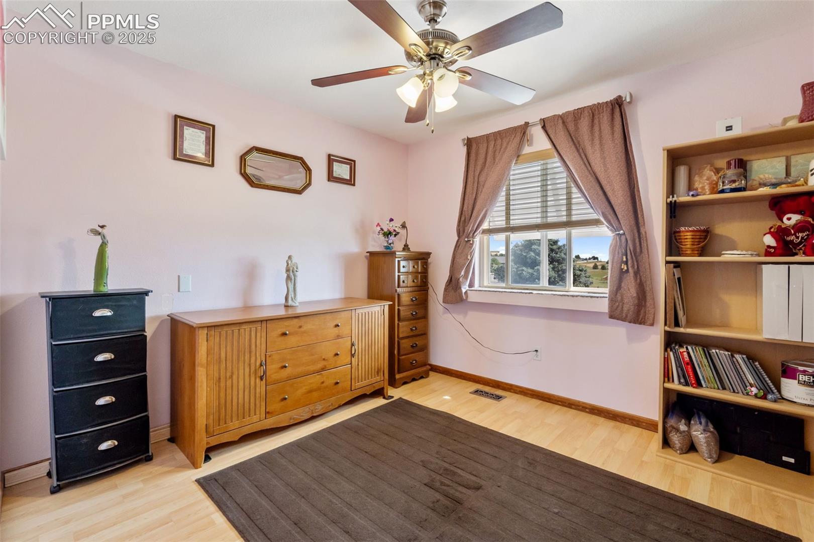 Secondary upper level bedroom with natural light and wood floors