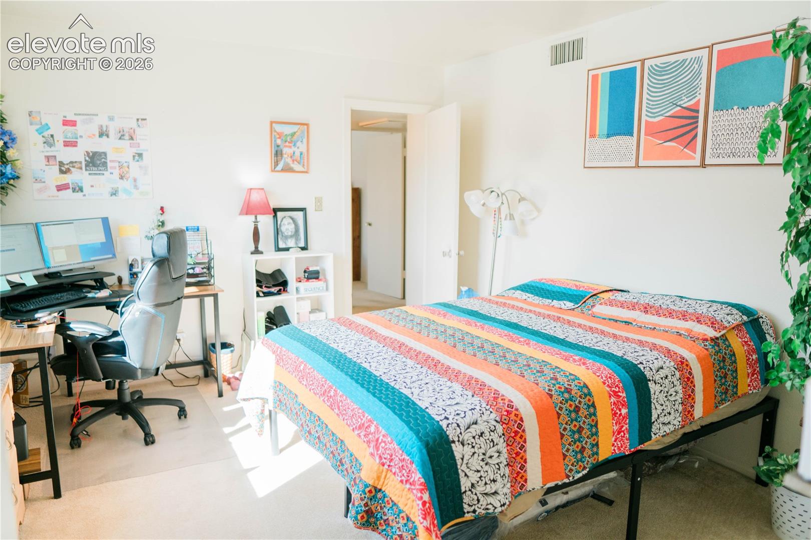 Light-colored wall finishes, carpeted flooring, and a door frame