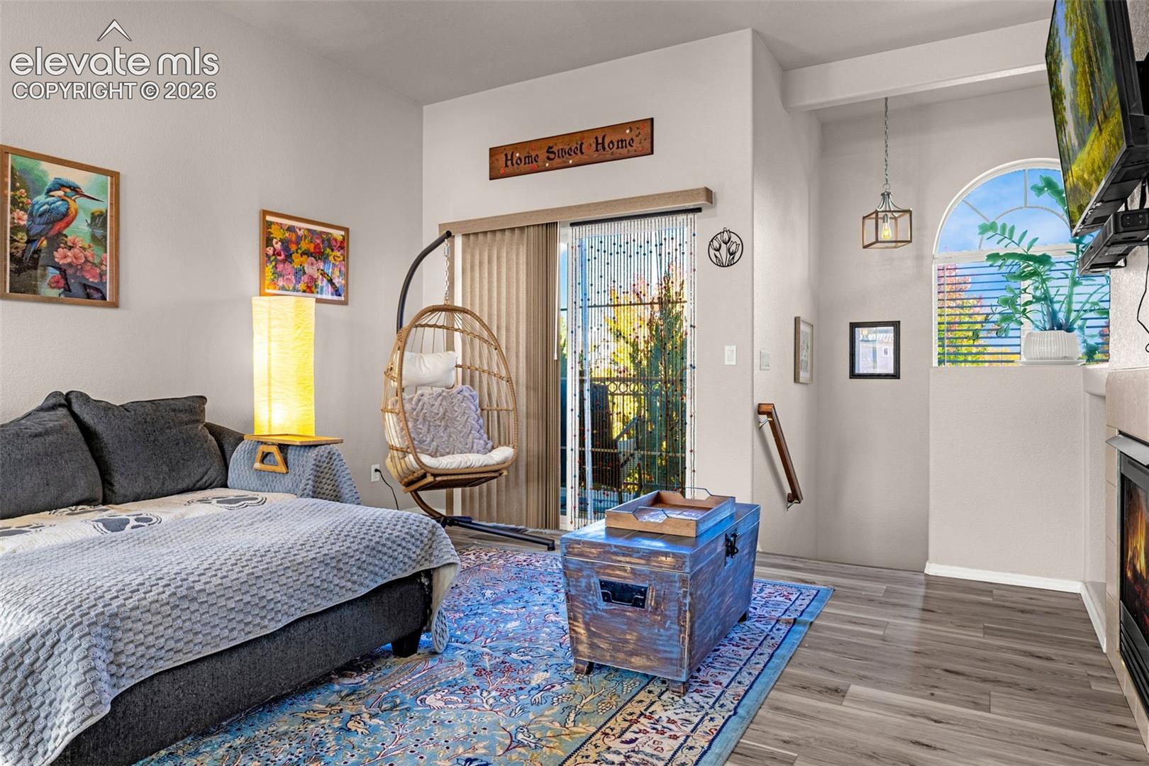 Sliding glass door, wood-finish flooring, arched window, and built-in fireplace
