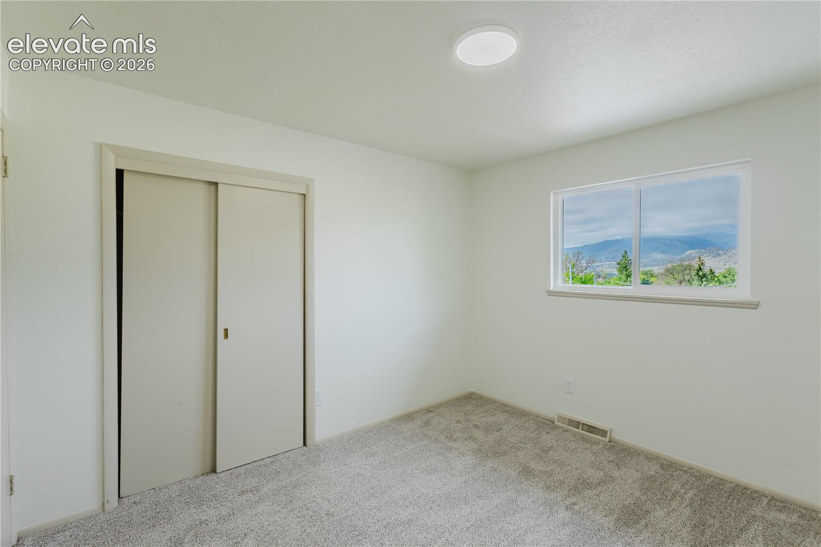 Bright room with a large window framing distant mountain scenery