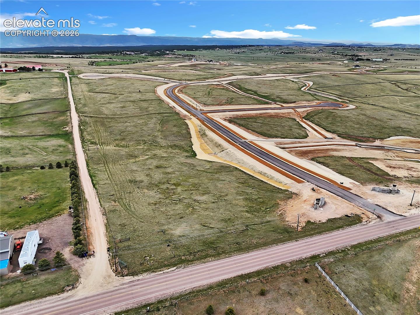 Expansive parcel featuring paved roadway access, established utility infrastructure, and mountain topography