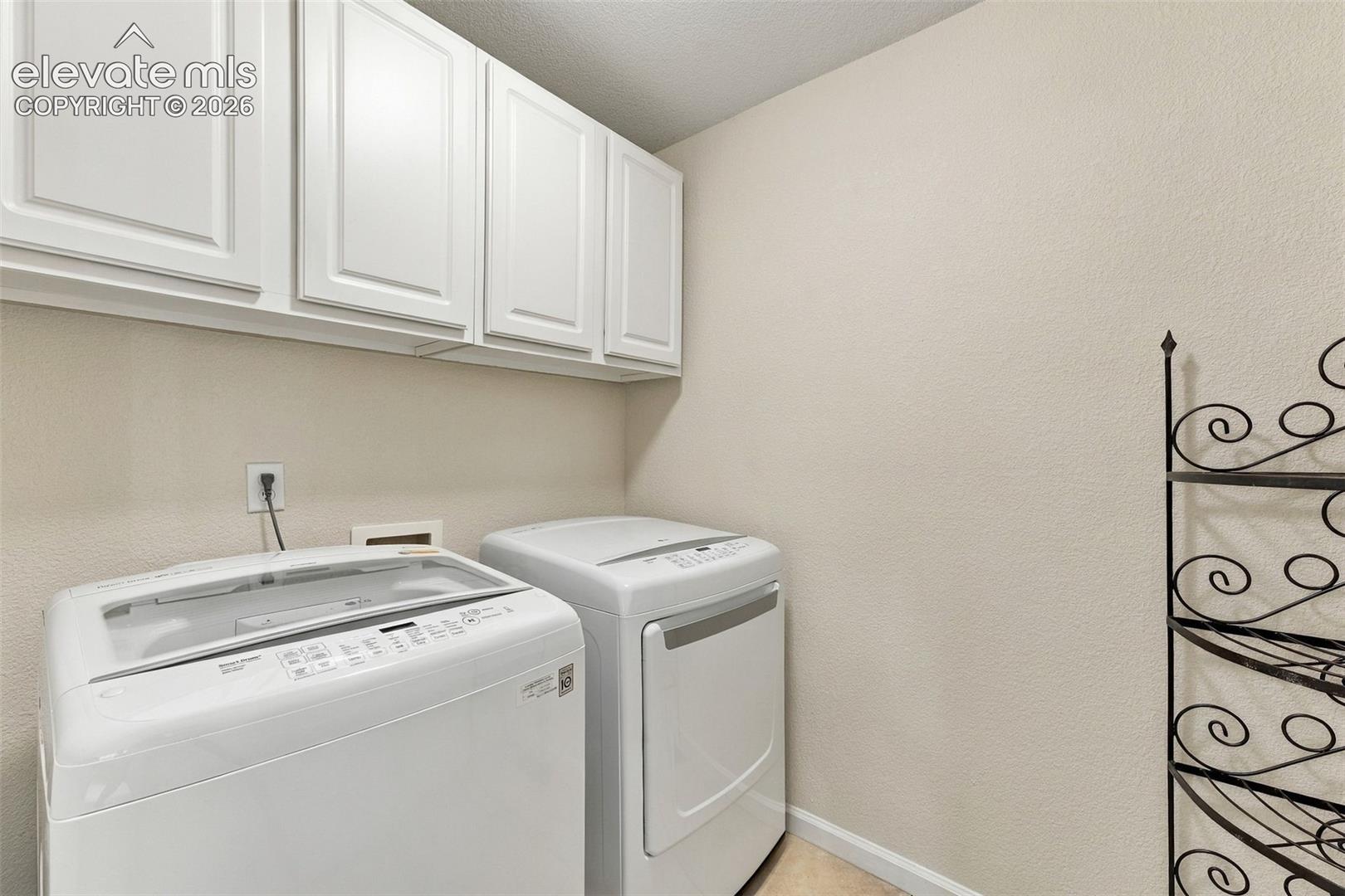 Laundry area featuring white shaker-style wall cabinetry