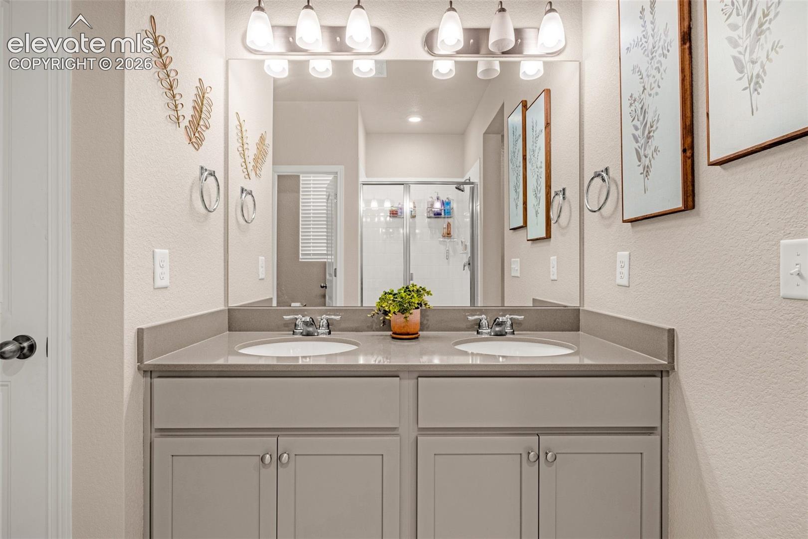 Dual vanity with undermount sinks, gray cabinetry, and a spacious countertop
