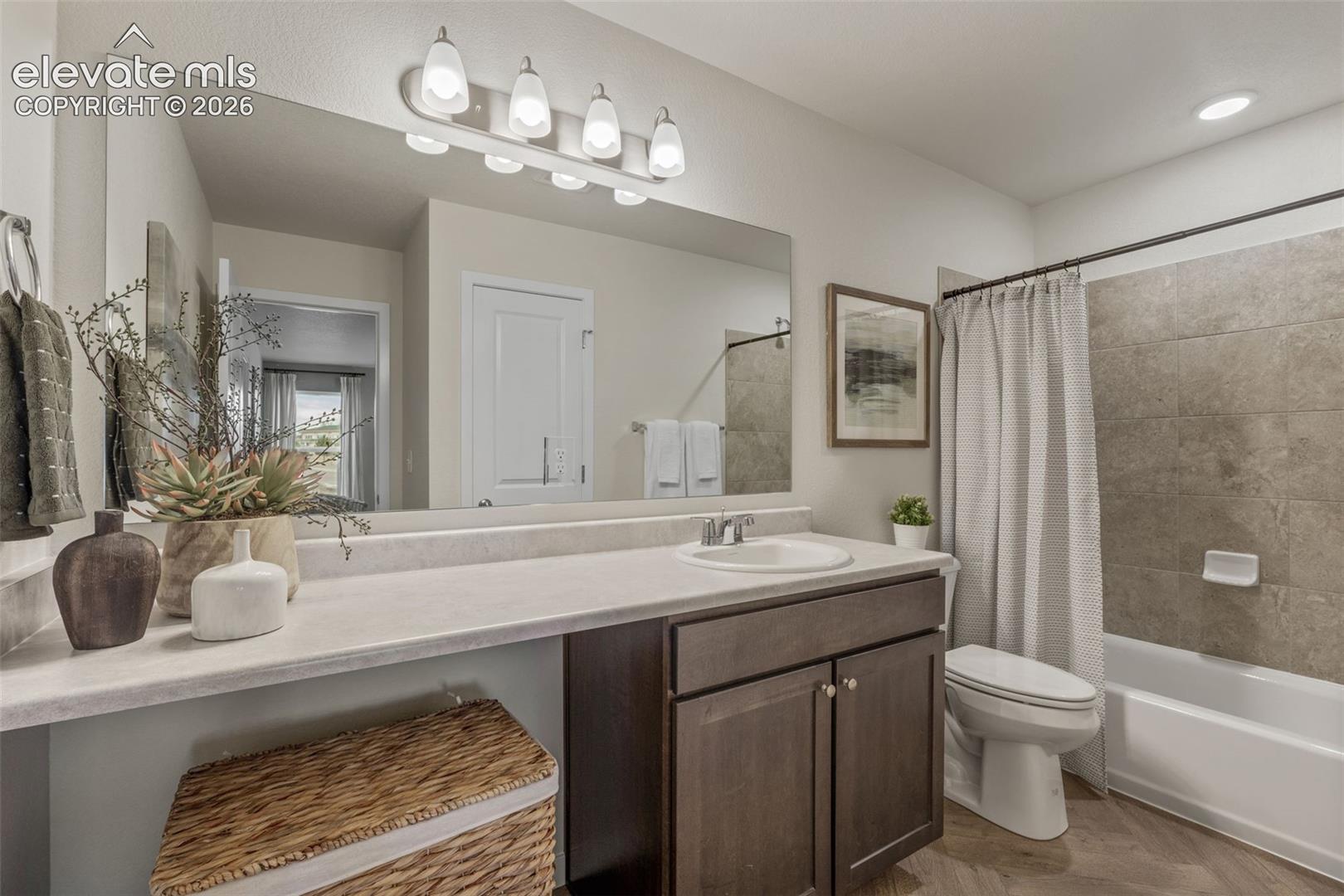 Vanity with an integrated sink, dark wood-finish cabinetry, and a large mirror with a five-bulb light fixture