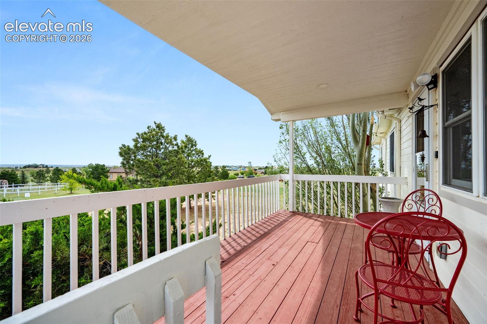 Covered wood-deck balcony with white railing