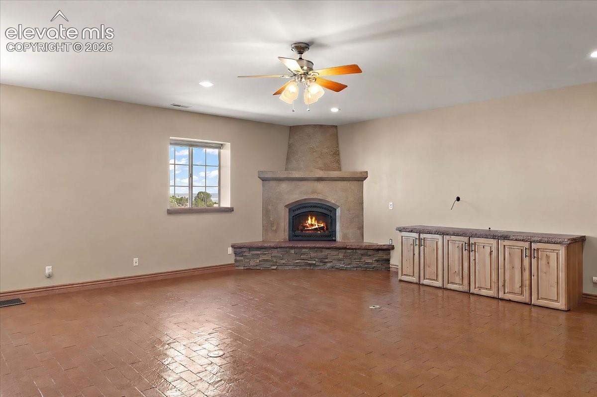 Living room with brick floor, storage for entertainment equipment and a gas fireplace