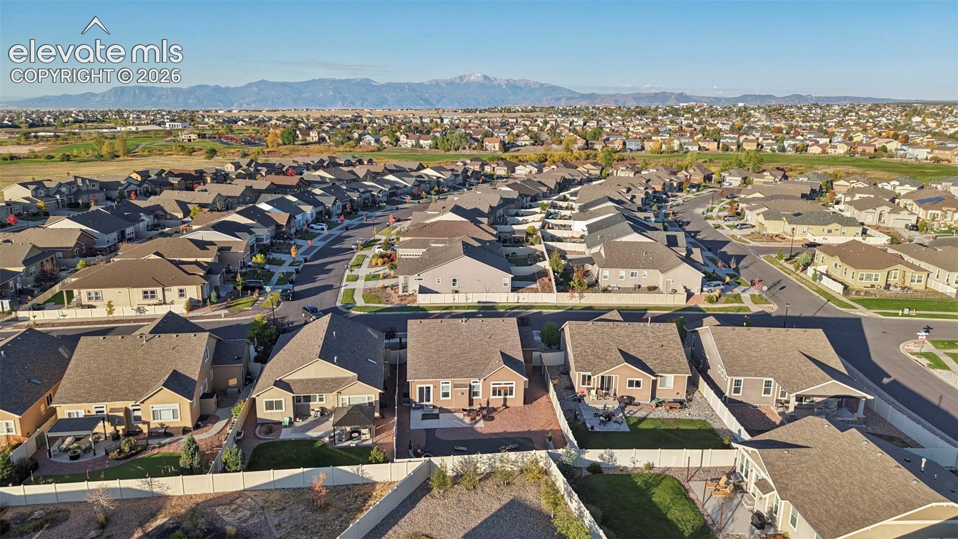 Residential neighborhood with extensive housing, paved streets, and distant mountain ranges