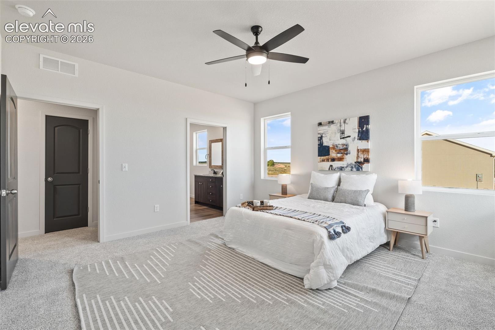 Carpeted flooring, white walls, and a dark-toned ceiling fan