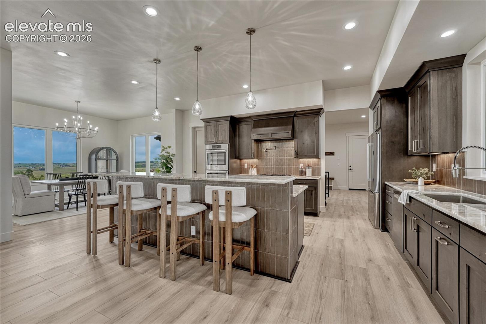 Beautifully appointed kitchen with sweeping island, quartzite countertops...