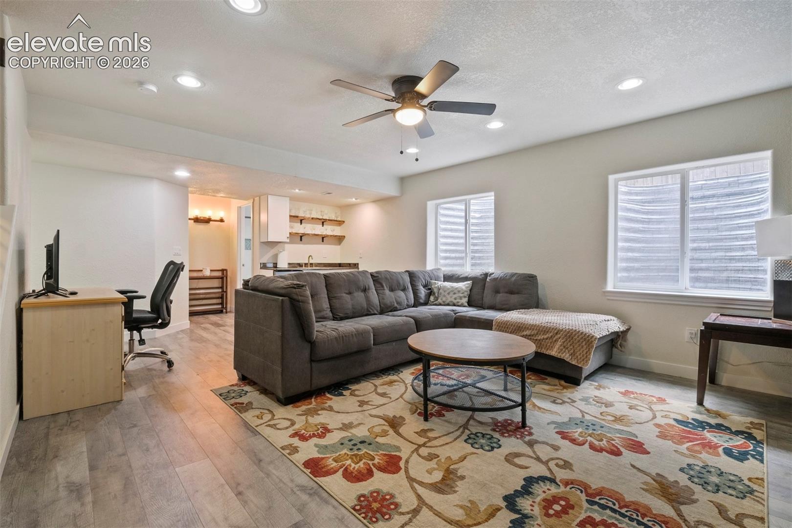 Basement: Open-concept living area featuring wood-finish flooring, recessed lighting, and a ceiling fan