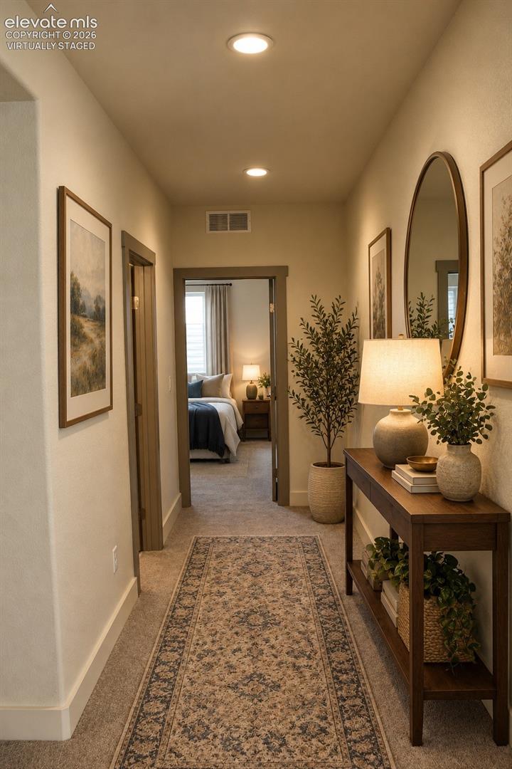 Virtually staged Recessed ceiling lighting illuminates the hallway with neutral wall tones and carpet flooring