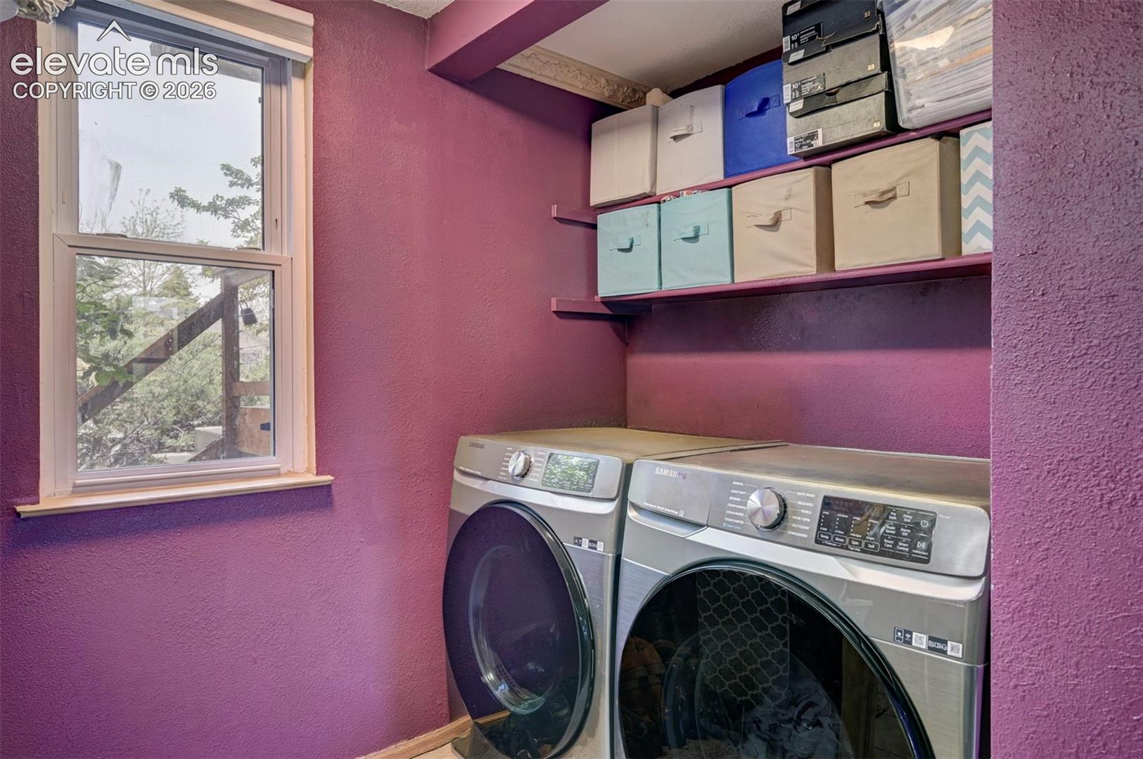 Functional utility space featuring a double-hung window, built-in shelving, and a textured purple wall finish