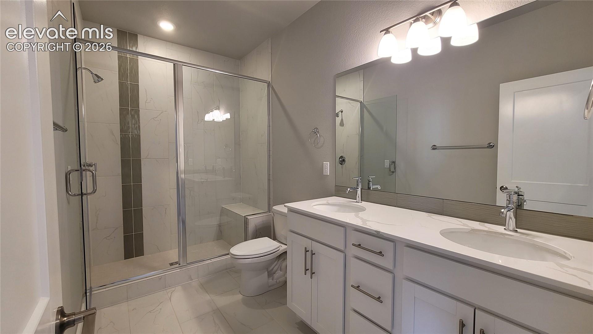 Primary Bathroom with double vanities, quartz countertop, shower with bench and tile surround! 