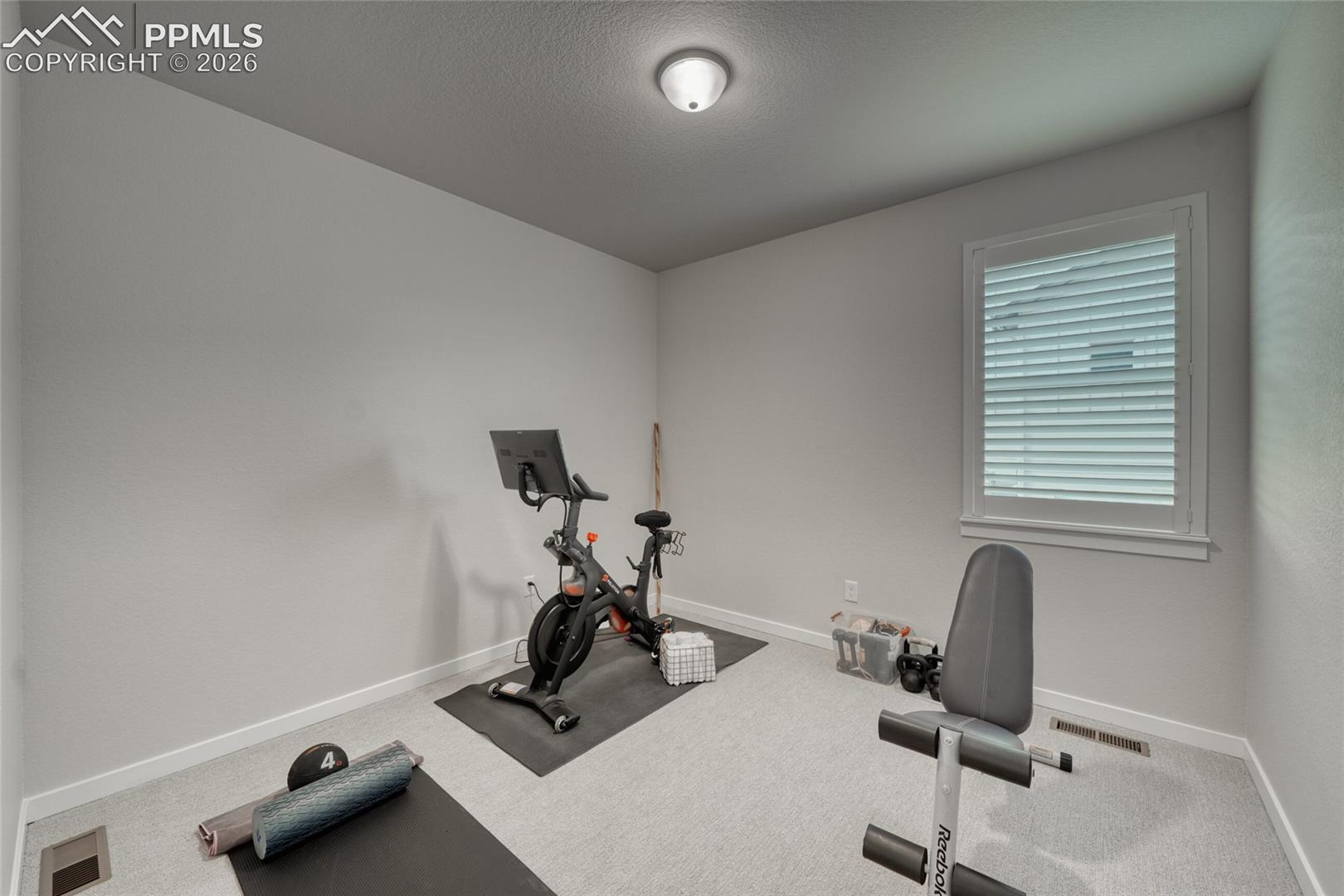 Workout area with carpet and a textured ceiling