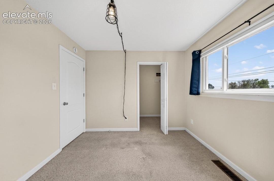 Textured carpeting, neutral wall paint, a white-framed window, and a recessed closet