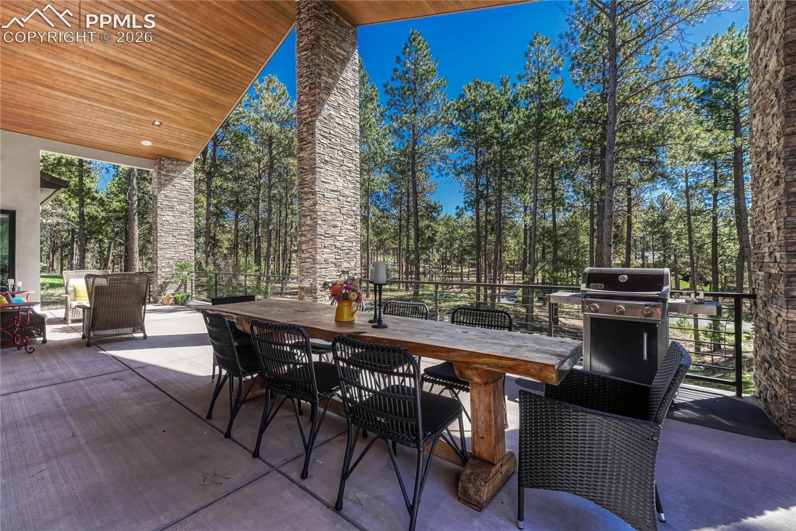 View of patio with outdoor dining area and grilling area