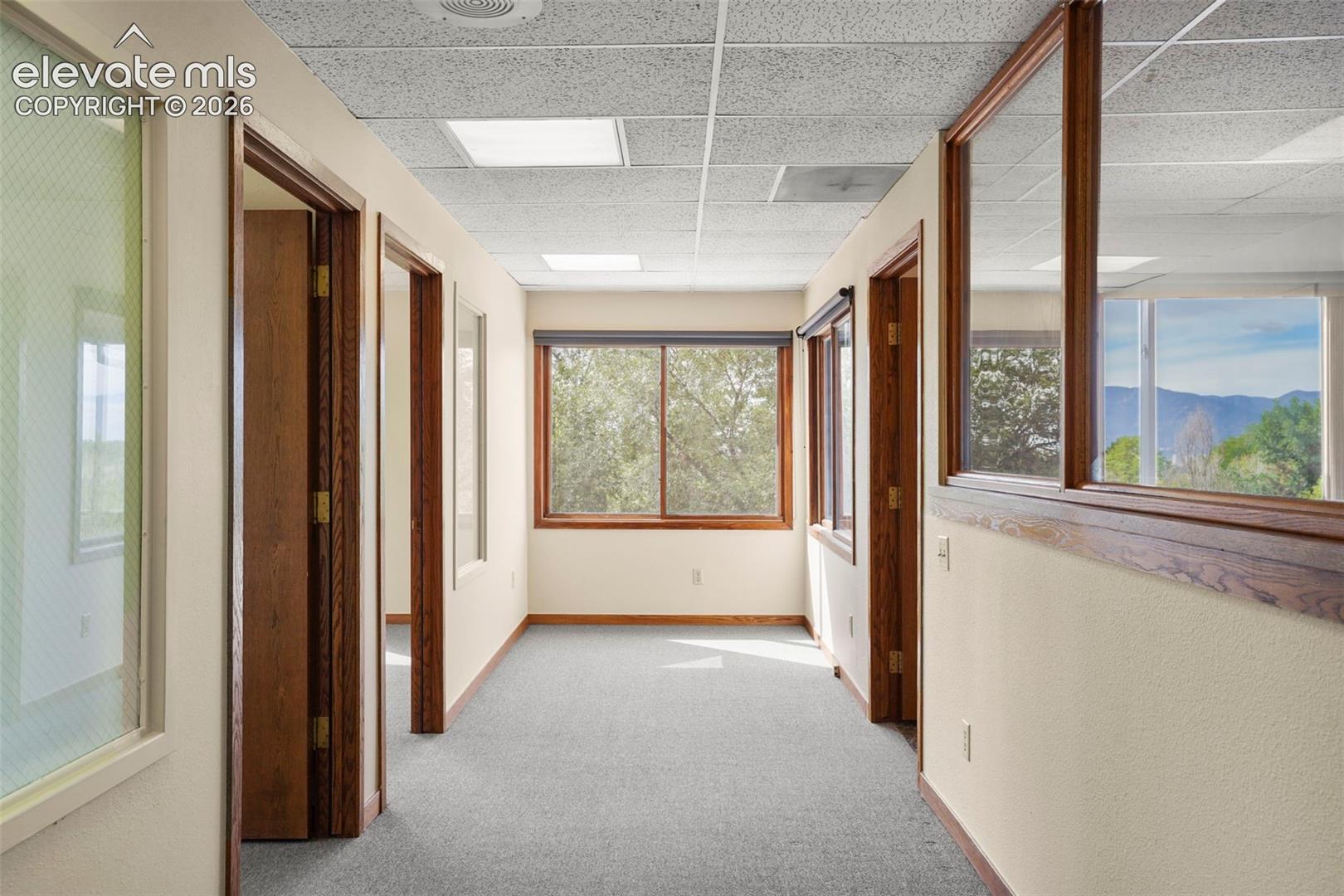 Upper Floor hallway. Far end has been used as small reception area. There is an exit to a small deck and exterior stairs on N. end of hallway.