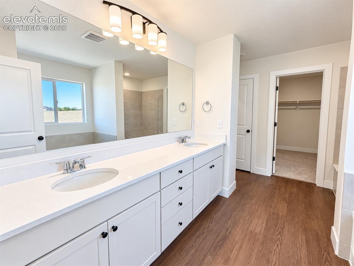 Dual vanity with white cabinetry and integrated sinks