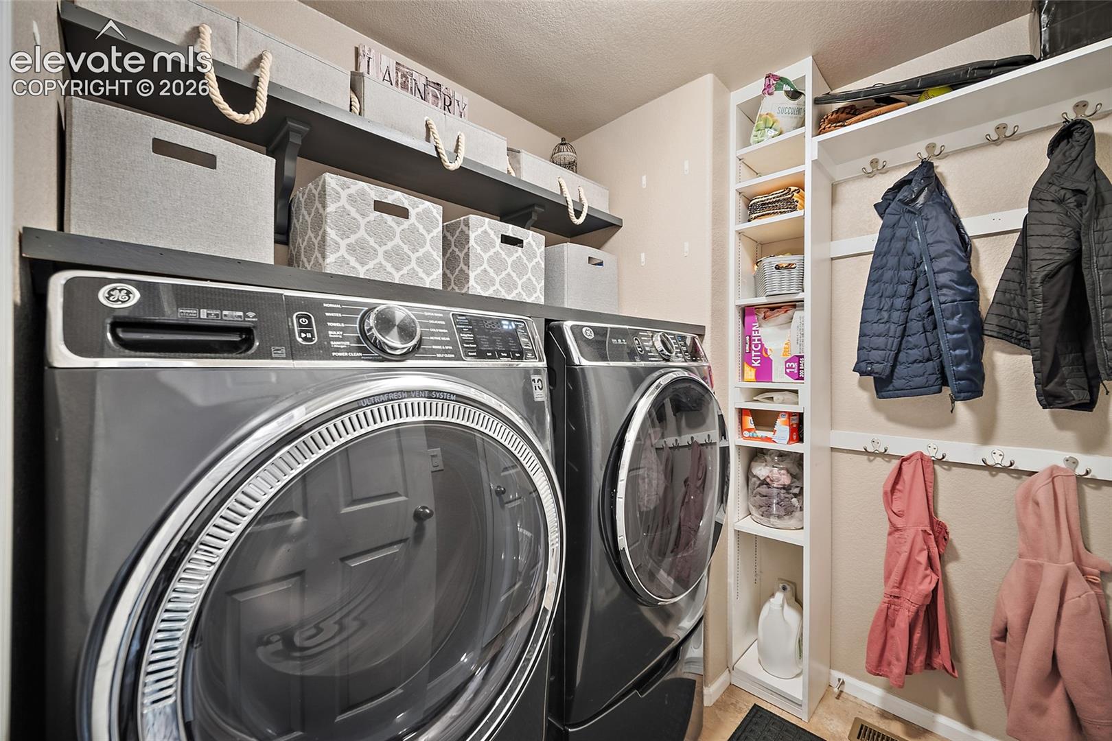 Main-level laundry room with added cabinetry and shelving for storage.