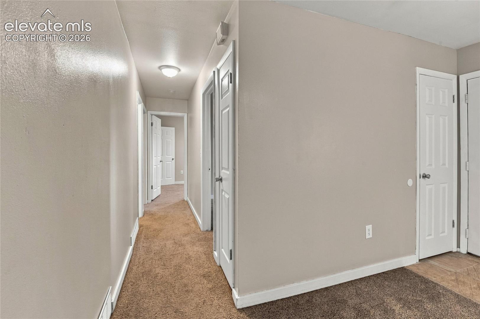 Hallway and secondary bedroom featuring neutral wall finishes, recessed ceiling lighting, and closet storage options with white six-panel doors