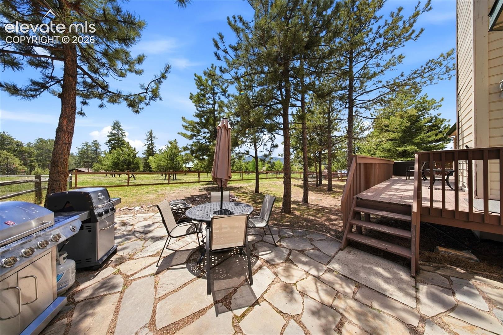Stone patio with a slatted privacy fence