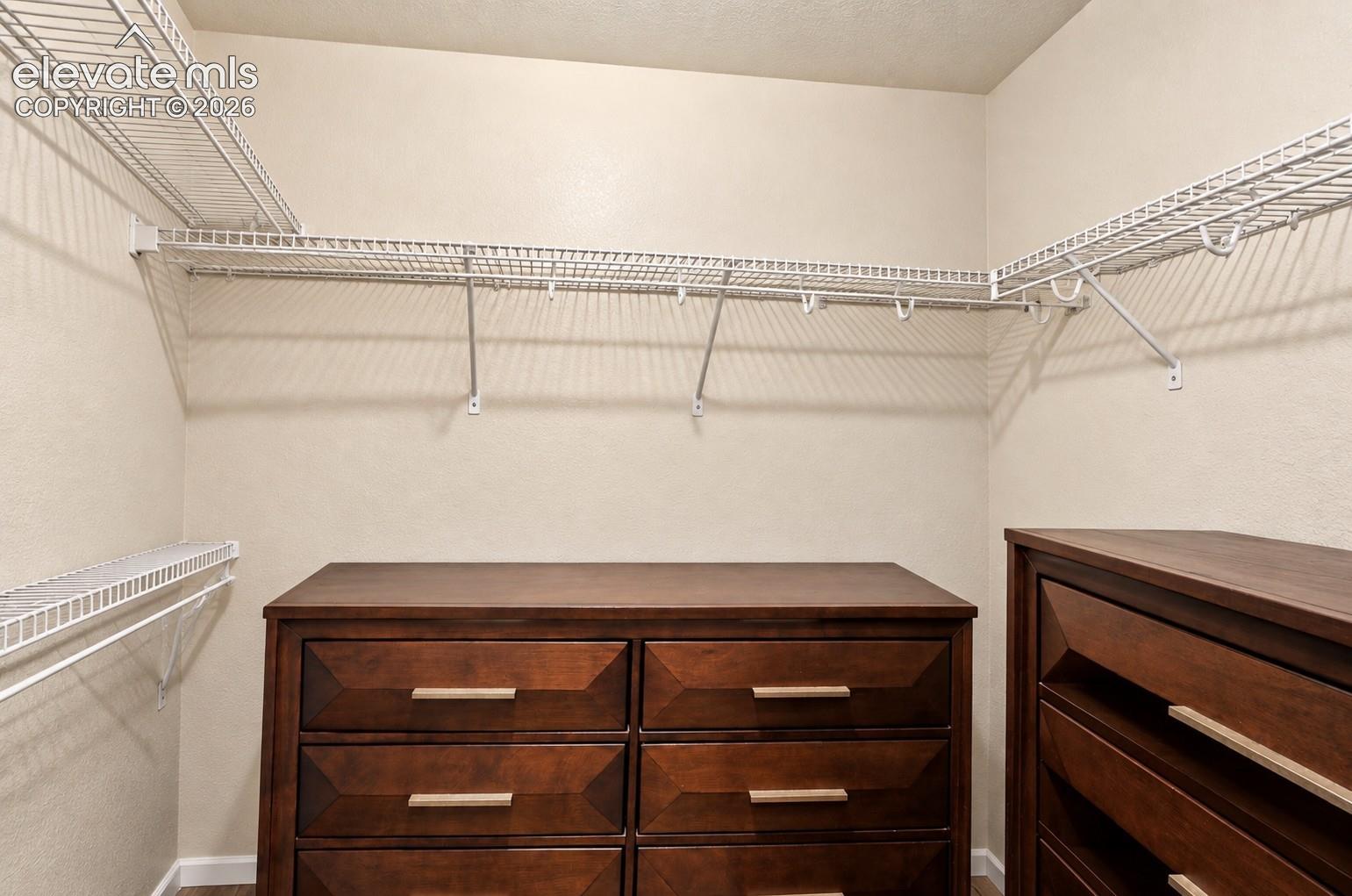 Integrated wire shelving system, dual wood-finish drawer units, and neutral wall tones