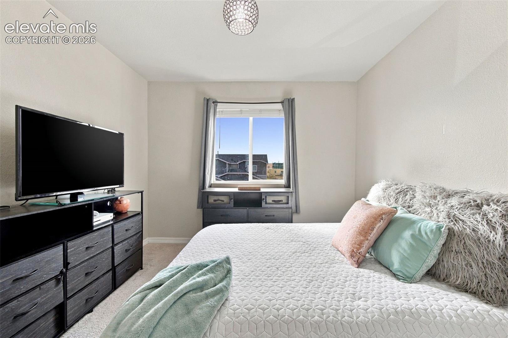 Neutral-toned room featuring a single-pane sliding window, recessed ceiling lighting, and carpeted flooring