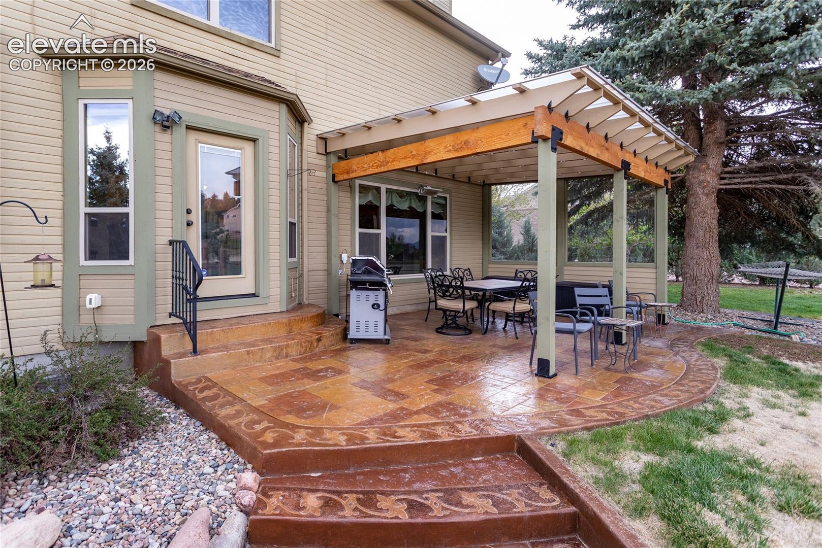 Beautiful Stamped Concrete and Covered Patio overlooks the Yard and Open Space