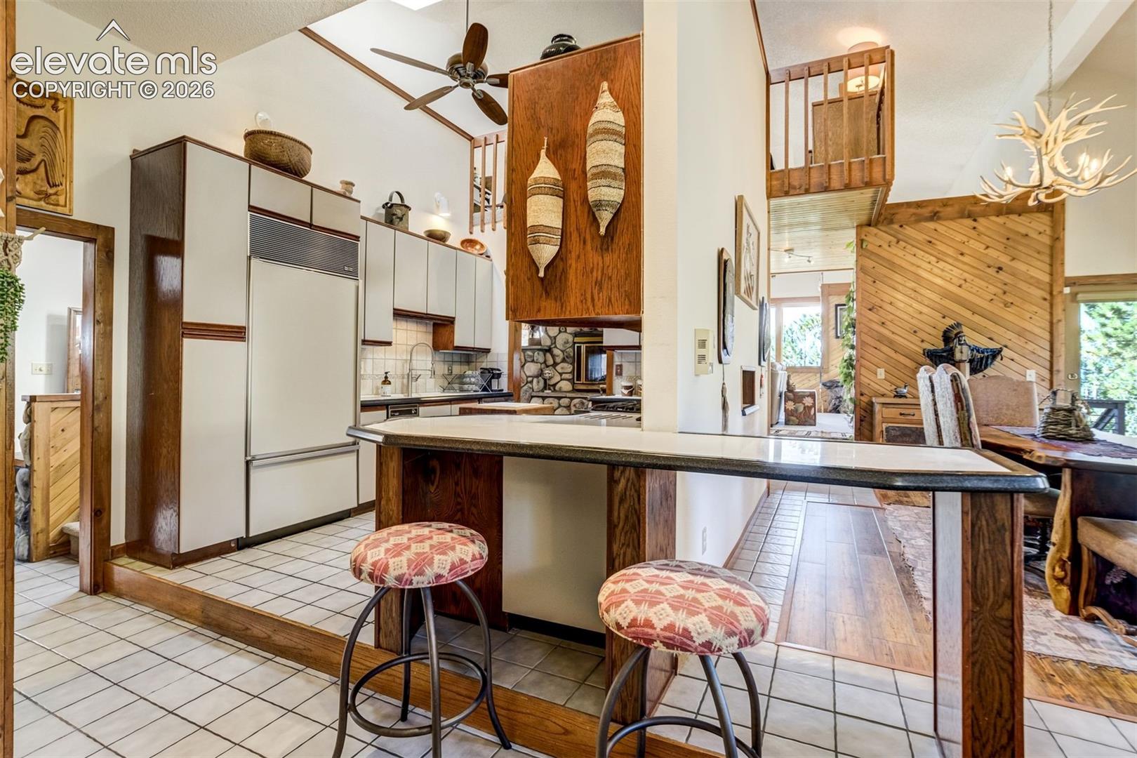 Kitchen has a solid surface counters, serving opening in the cabinetry to the dining room and breakfast bar that can seat on both sides