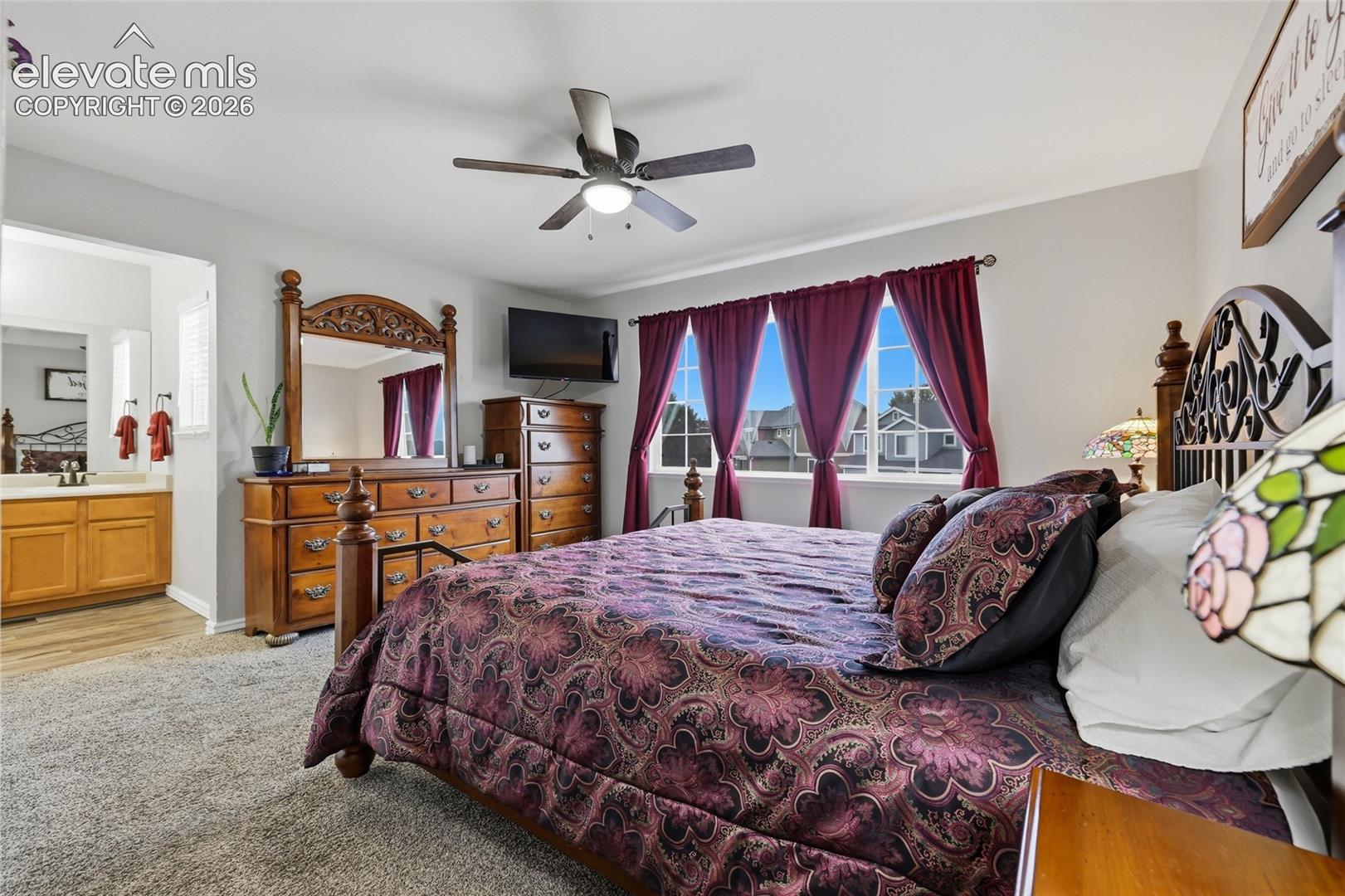 Bedroom with carpet and a ceiling fan.  Private en-suite bath