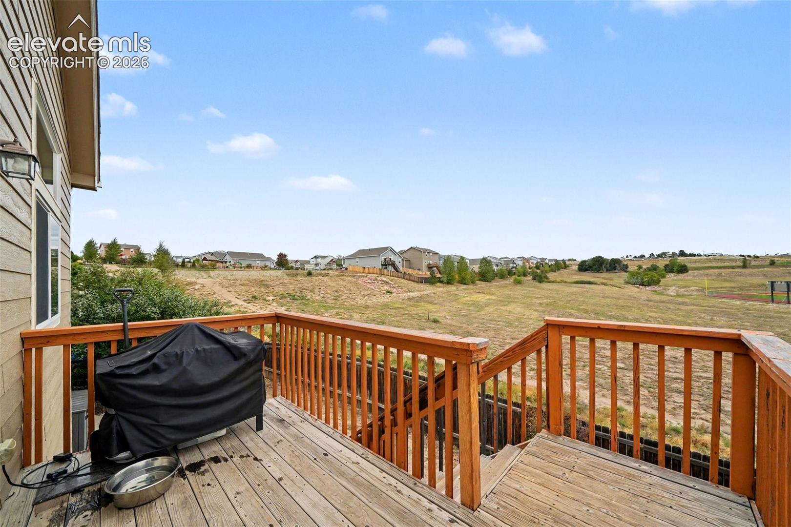 Expansive outdoor deck located off of the dining area that overlooks the adjoining open space.