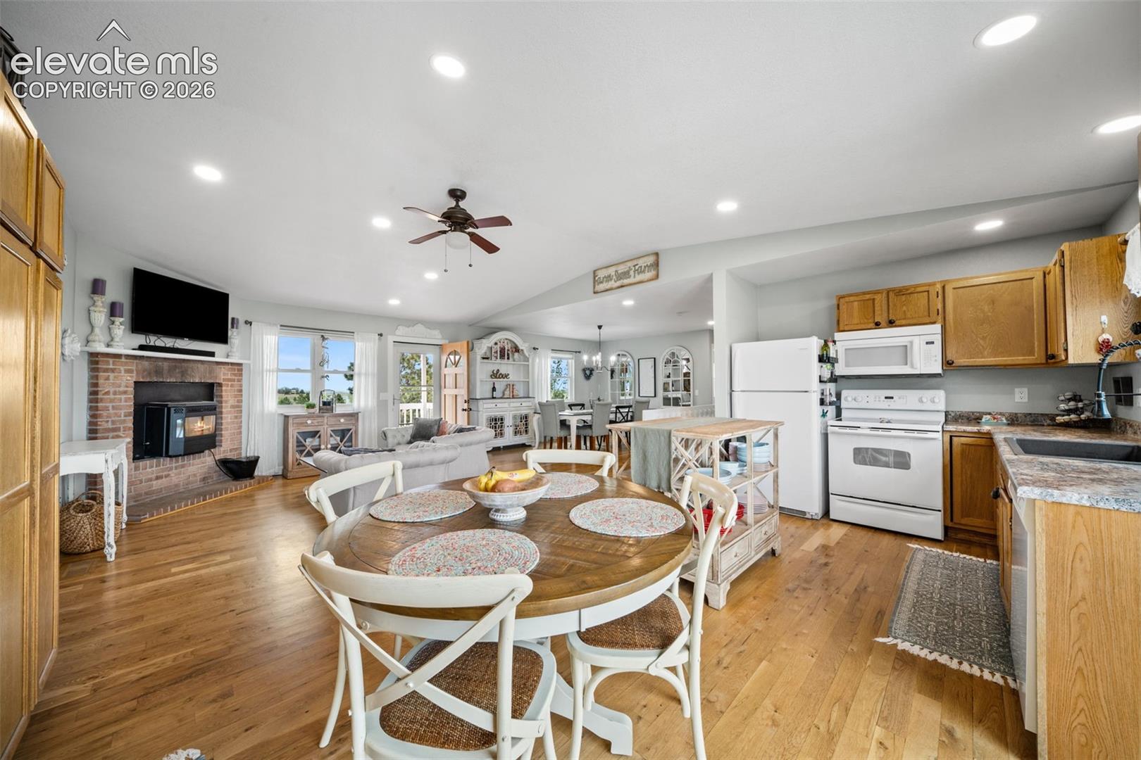 Open-concept living space featuring wood-finish flooring, recessed lighting, and a ceiling fan