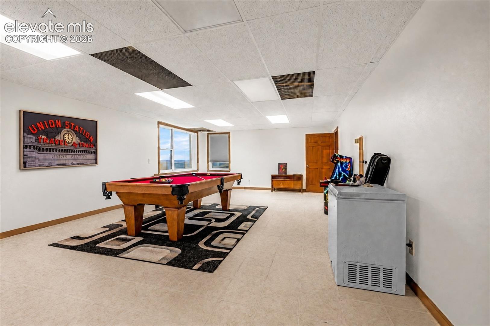 Expansive recreational room featuring large windows, light-colored flooring, and recessed lighting