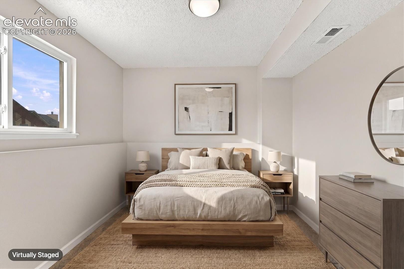 Neutral interior featuring textured ceiling, single-pane window, and flush-mount light fixture