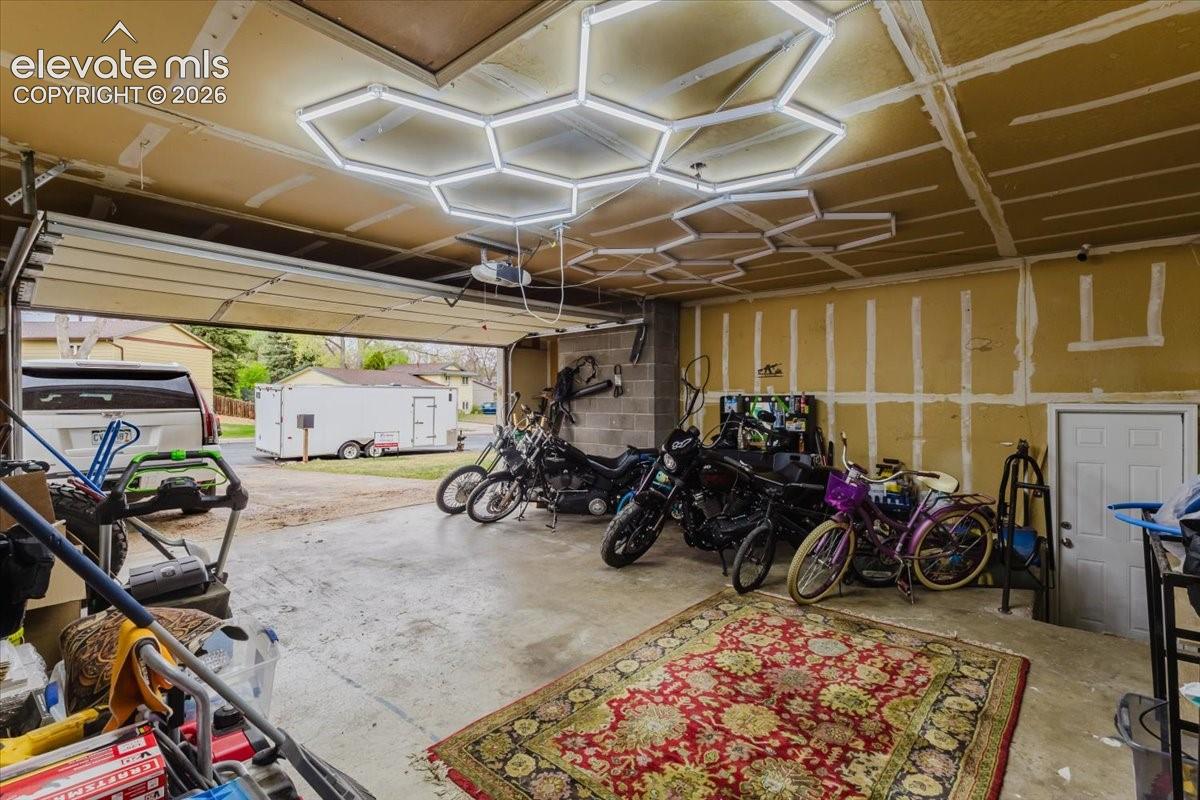 Spacious garage featuring a concrete floor, overhead garage door, and a dedicated side door access
