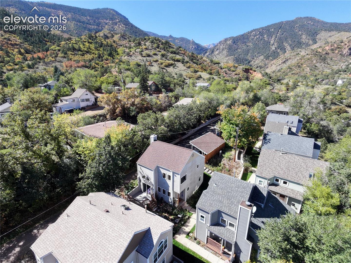Mountainous backdrop with surrounding mature trees, offering a private setting
