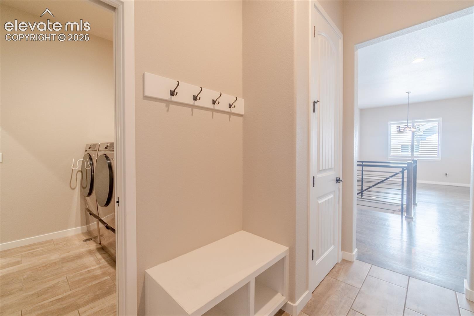 Entryway featuring tiled flooring, built-in bench with storage, and coat hooks