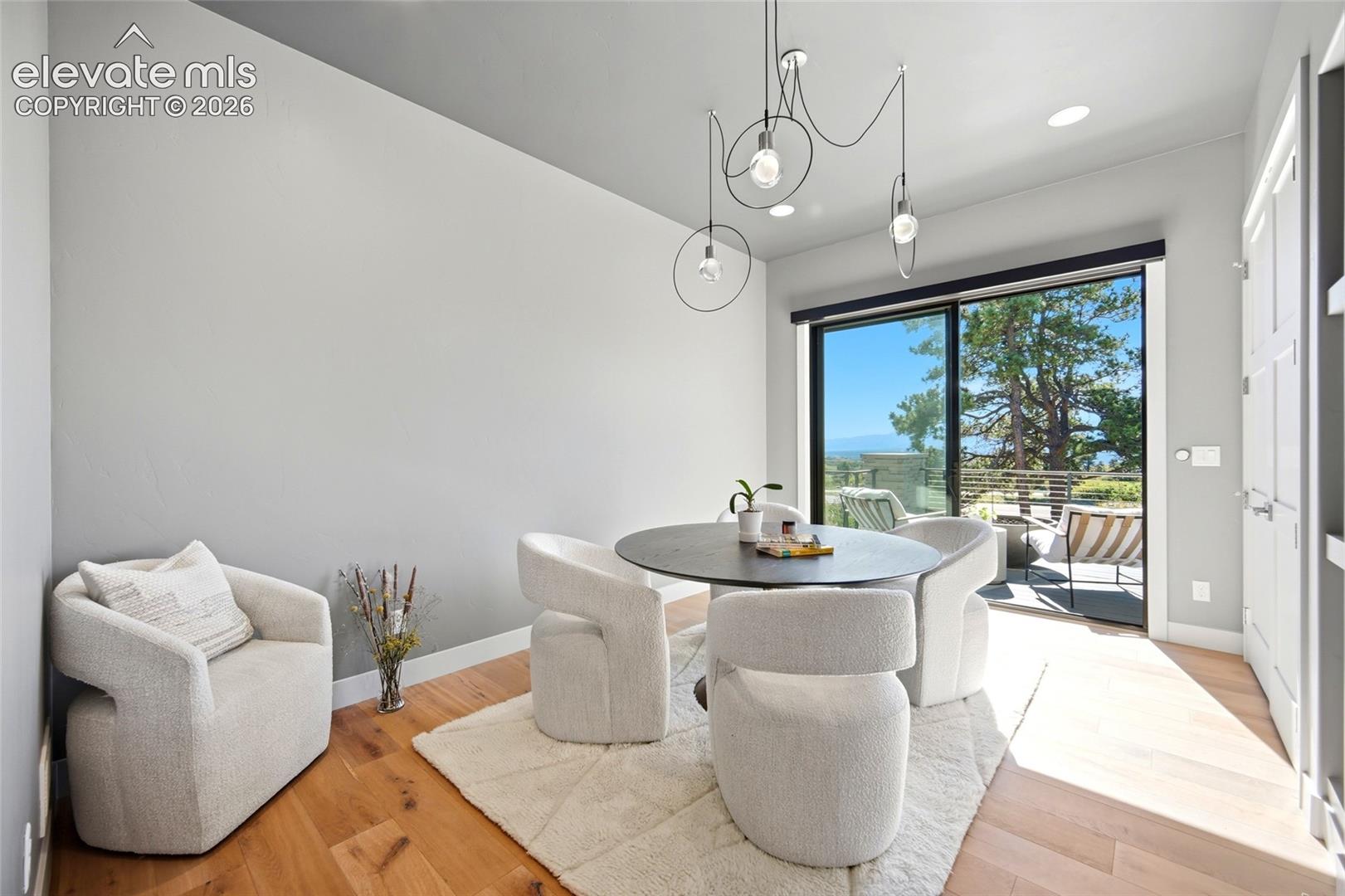 Sliding glass door to an exterior patio, wood-finish flooring, recessed lighting, and a modern chandelier
