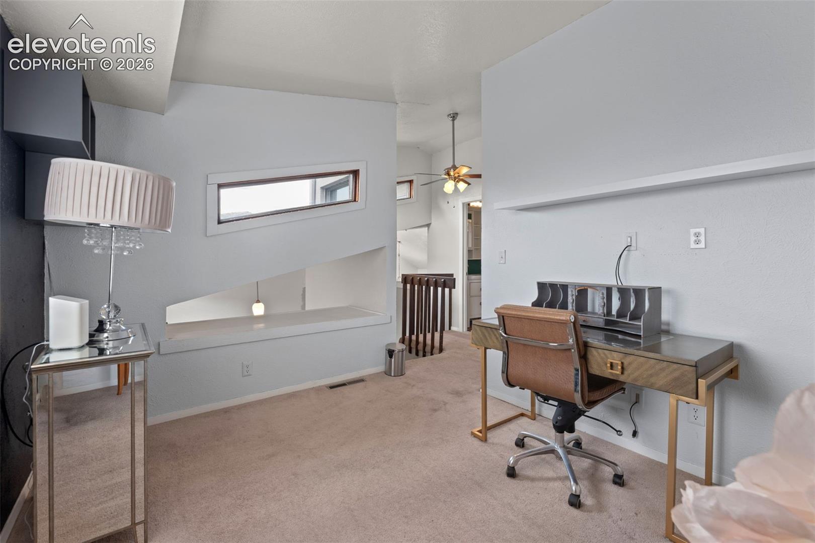 Built-in architectural shelving, a distinct angled window, and light-colored carpeting