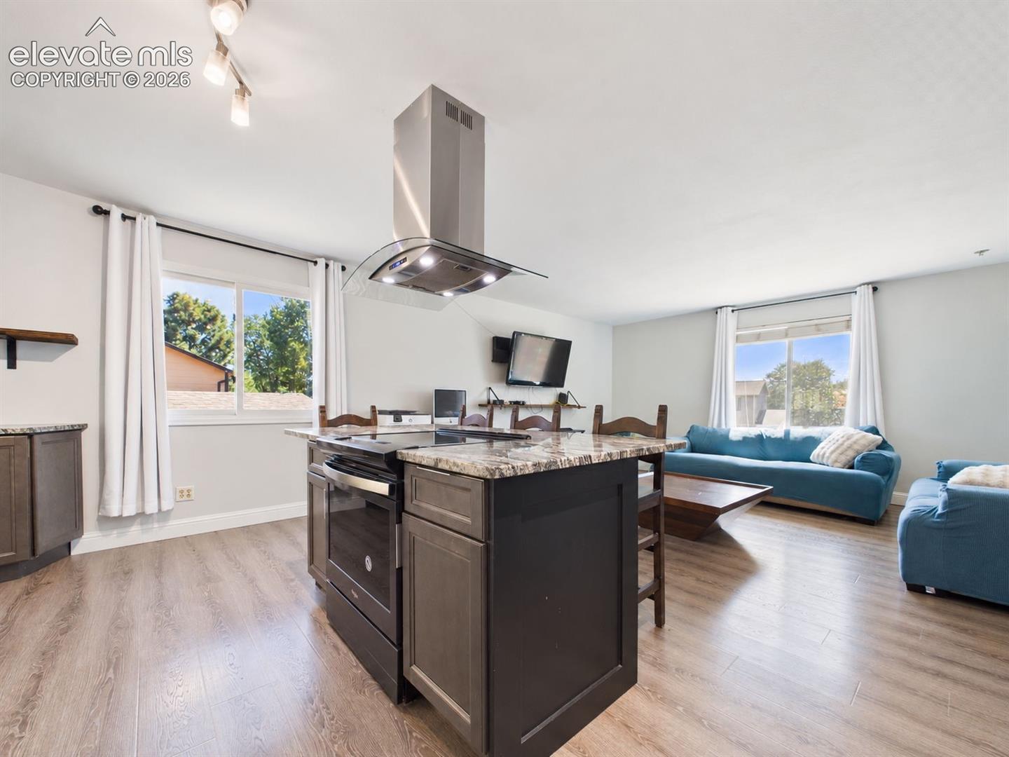 Open-concept design creates an easy visual connection between the kitchen and living room, complemented by updated flooring and abundant natural light.