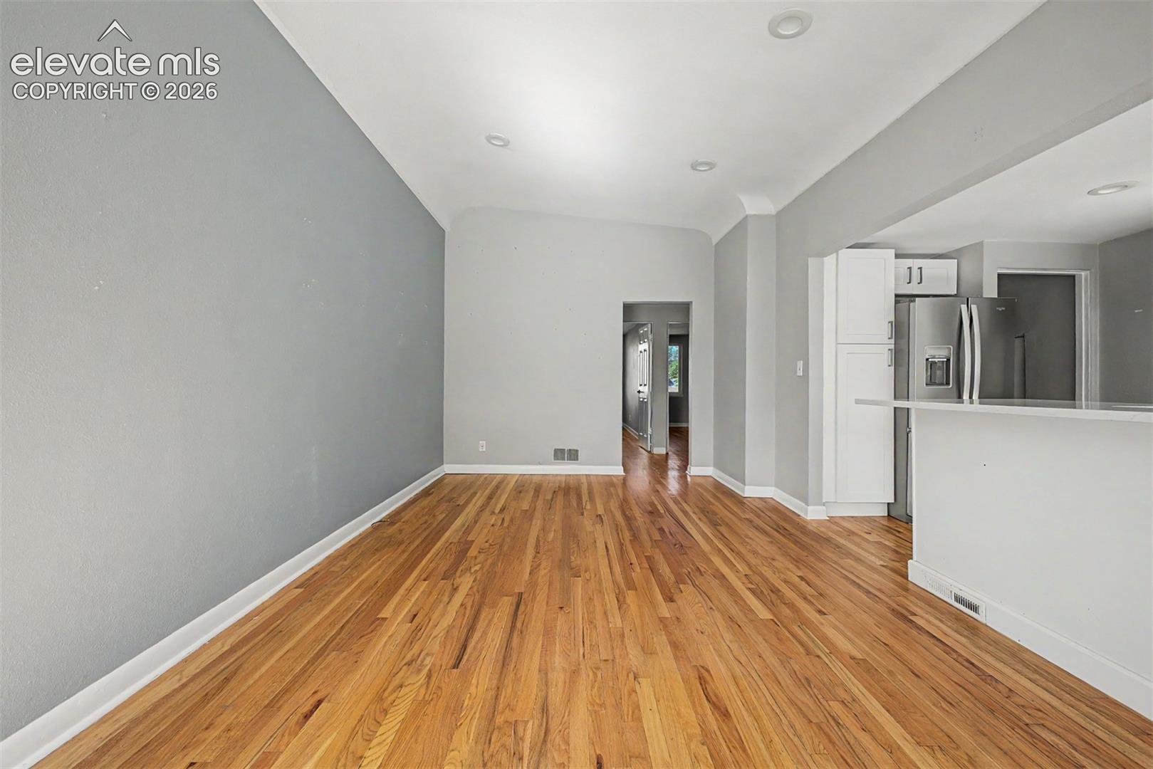 Open-concept living space featuring wood-finish flooring, recessed lighting, and light gray walls